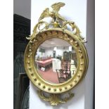 A Regency Style Convex Wall Mirror, with eagle surmount and foliate garland, with beadwork frieze,