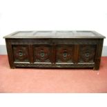 An XVII Century Joined Oak Coffer, with a four panelled top, rosette frieze, four carved panel base,