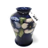 A Moorcroft Pottery Vase, of pear shape, painted in the 'Pansy' pattern against a dark blue