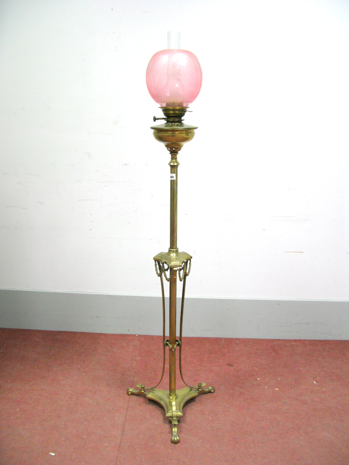 An Early XX Century Floor Standing Brass Oil Lamp, the central column with foliate swags and