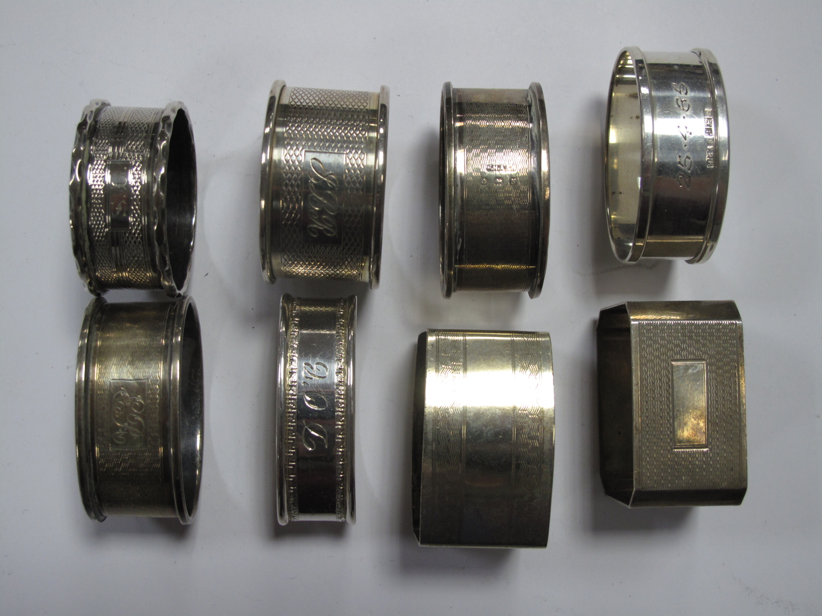 Seven Assorted Hallmarked Silver Napkin Rings, engraved/initialled; together with a EPNS example.
