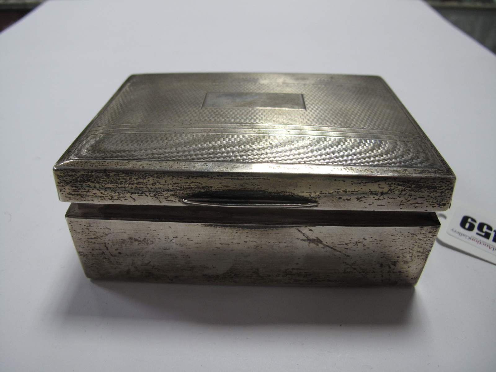 A Hallmarked Silver Cigarette Box, of rectangular form with engine turned lid, 11.5cm wide.