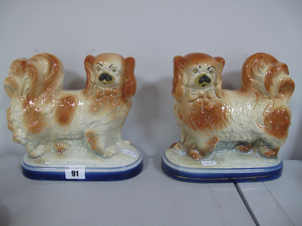 A Pair of XIX Century Staffordshire Spaniels, on oval shaped bases.