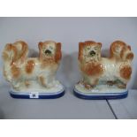A Pair of XIX Century Staffordshire Spaniels, on oval shaped bases.