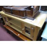 A Veneered Light Oak Television Stand, with glazed doors, flanking open shelves, 119cm wide.