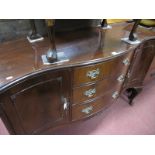 A Mahogany Serpentine Shaped Sideboard, with three central drawers, flanking cupboard doors on