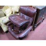 Ekornes Red Leather Reclining Armchair; together with a stool.