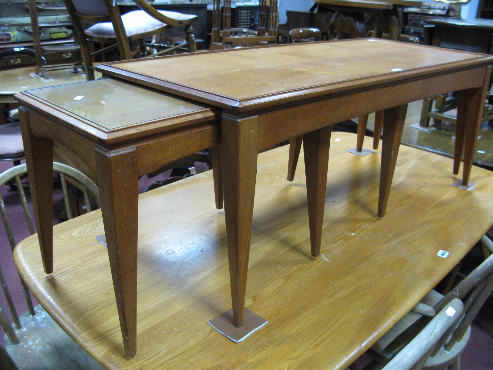 A Teak Nest of Tables, with rectangular tops on tapering legs.