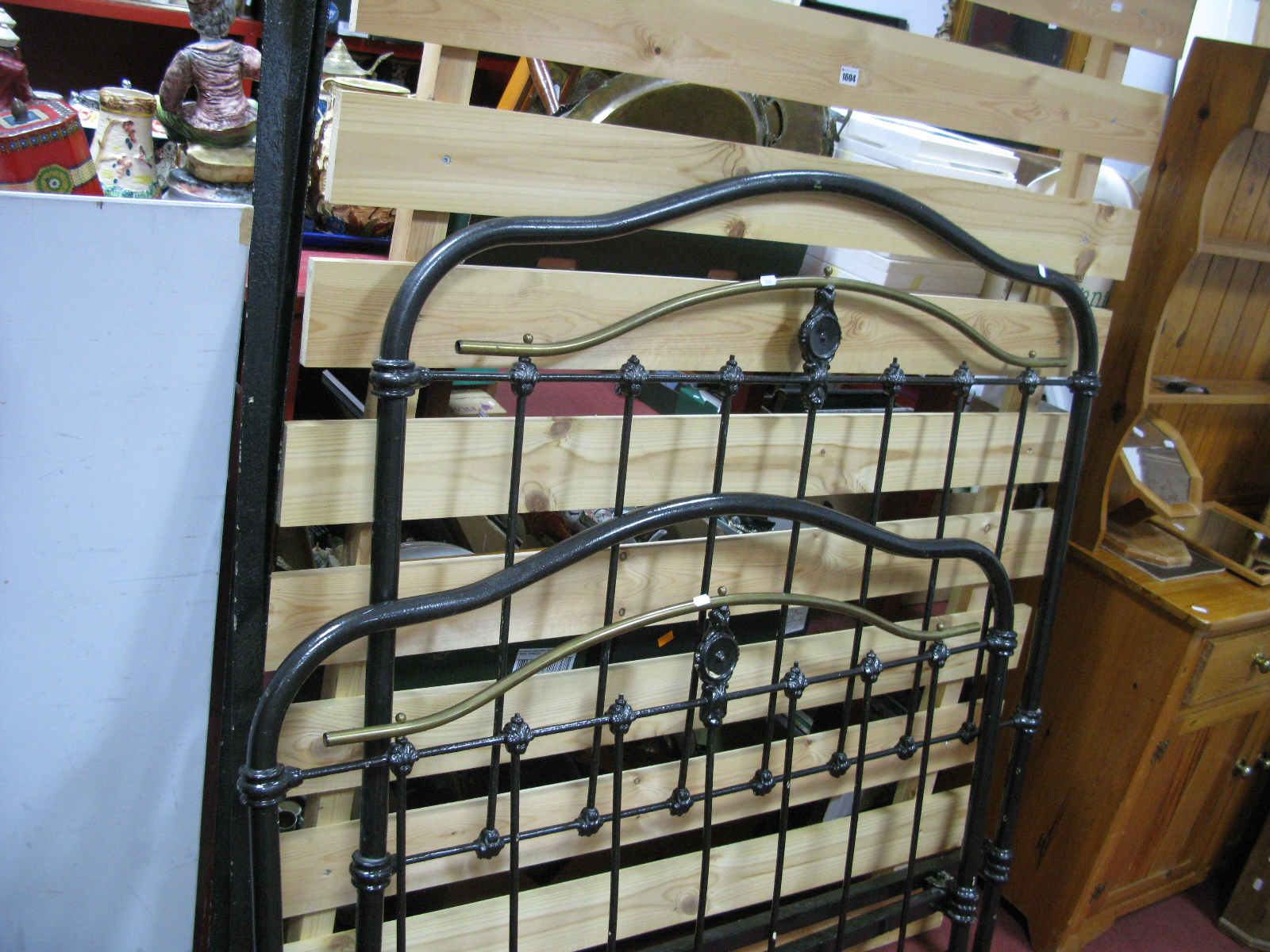 An Edwardian Black Painted Cast Iron and Brass Four Foot Bedstead, with larger later pine base.