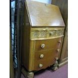 A Mid XX Century Oak Bureau with a fall front, shaped top drawer over three long drawers, on cup