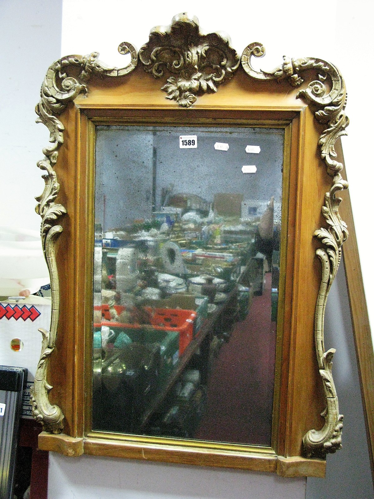 A Continental Pine Framed Bevelled Wall Mirror, with scroll mounts 57cm wide.