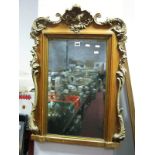 A Continental Pine Framed Bevelled Wall Mirror, with scroll mounts 57cm wide.