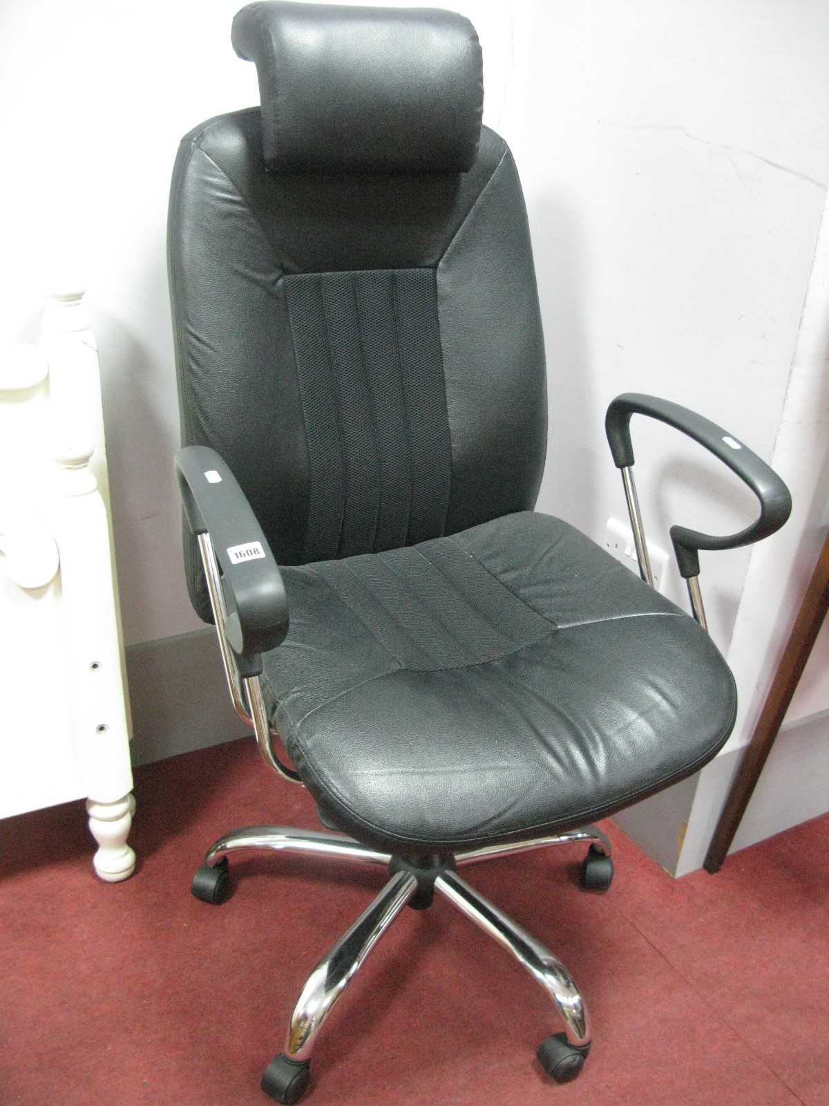 A Black Office Chair, with adjustable action on chromed five star base.`