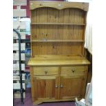A Pine Dresser Rack, with two shelves, shaped sides, base with two drawers over cupboard doors.