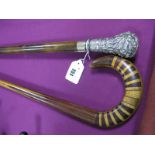 A Mid XX Century Walking Stick, with ornate silver plated handle plus another wooden example with