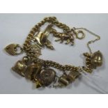 A Curb Link Bracelet, to heart shape padlock clasp, suspending assorted novelty charm pendants,