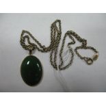 A Polished Green Hardstone Pendant, stamped "14K", on a chain stamped "9K".