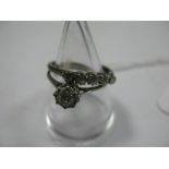 A Single Stone Diamond Ring, the brilliant cut stone illusion set, between knife edge shoulders,