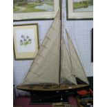 A Modern Wooden Model of a Yacht, on stand, c90cm long with sails.