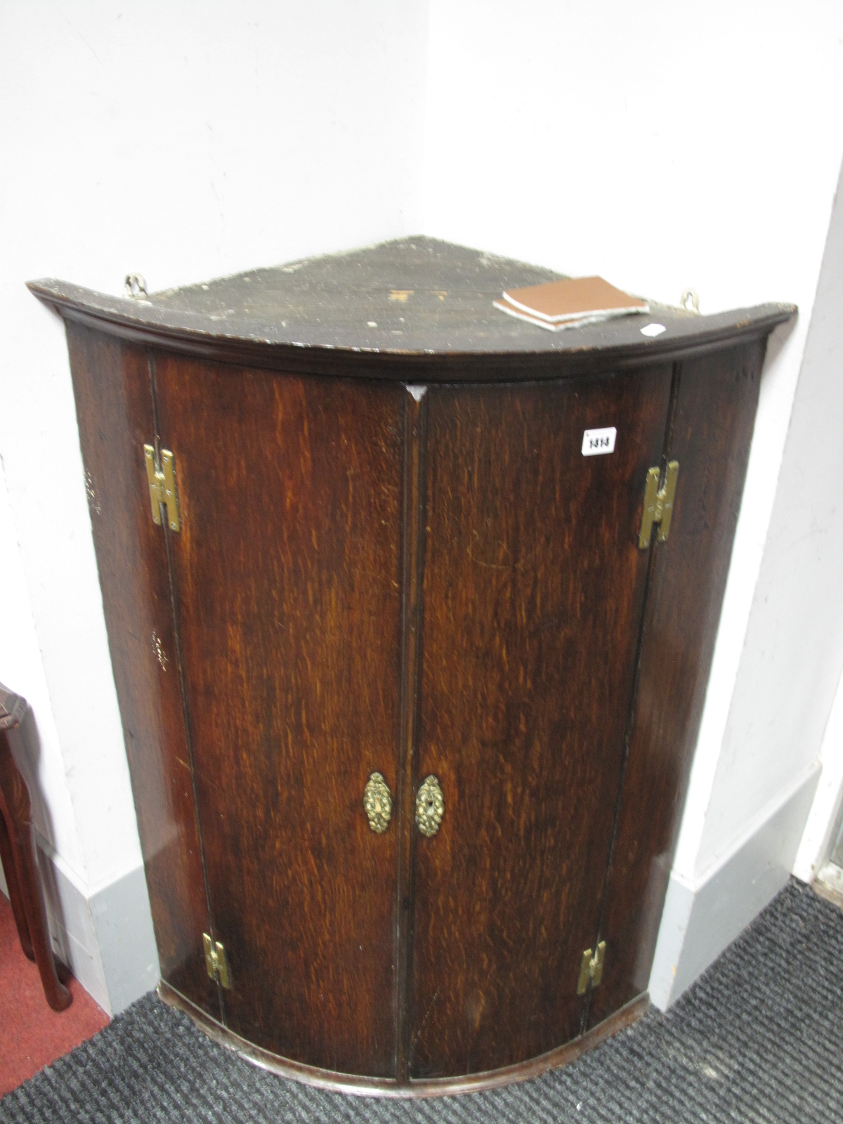 An Early XIX Century Oak Bow Fronted Corner Cupboard, with internal shelves, hinges