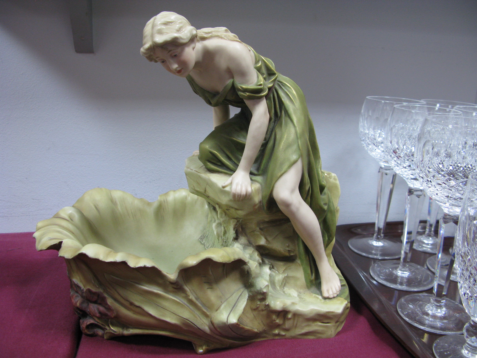 A Royal Dux Model of a Maiden Climbing on a Rock Beside a Shell Shaped Bowl, moulded with red