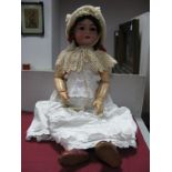 An Early XX Century Large Bisque Headed Doll, the head stamped "DEP", with sleepy eyes, open mouth