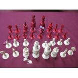 A Late XIX Century Bone Chess Set, with carved and turned pieces, half stained red. (32)