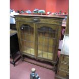 A 1920's Oak Bookcase, with stepped and rope twist top, twin leaded glazed doors, on barley twist