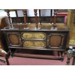 A 1920's Jacobean Style Oak Sideboard, with low back, twin drawers flanked by cupboard doors, on