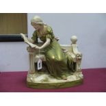 A Royal Dux Model of a Lady Seated Reading a Book Upon a Bench, upon a moulded rectangular base,