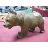 A Late XIX Century Black Forest Carved Model of a Bear, in growling pose, glass eyes, 27cm long.