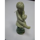 A Rare Royal Doulton Stoneware Figure of a Naked Child Holding It's Foot and Seated on a Tree Stump,