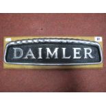 A Mid XX Century Daimler Bus Badge, presented on a wooden plinth.
