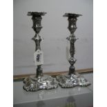 A Pair of Hallmarked Silver Candlesticks, London 1906, the knopped stems on shell moulded square