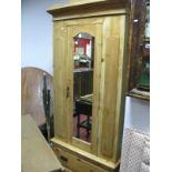 A Pine Wardrobe, with a shaped pediment, central arched mirror, door, long drawer on a plinth base.