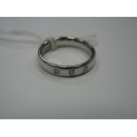 A Platinum Diamond Set Band, rub over set with three uniform brilliant cut stones.