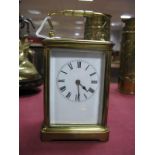 A Brass Cased Carriage Clock, white dial, Roman numerals, with carrying handle.