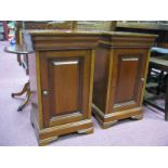 A Pair of Bedside Cupboards, with panelled doors, on bracket feet.