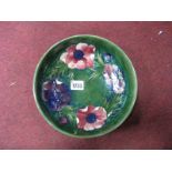 A Moorcroft Pottery Shallow Circular Bowl, painted in the 'Anemone' pattern against a blue green