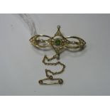 An Edwardian Peridot and Seed Pearl Set Brooch, of openwork design, circular collet set to the