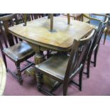 A 1930's Oak Draw Leaf Dining Table, on twin twelve sided supports; together with four chairs.