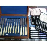 Cased Coffee Spoons and Tea Knives, together with a wooden cased set of twelve knives and forks,