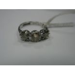 A Three Stone Diamond Ring, the old cut stones claw set, between knife edge shoulders, stamped "18ct