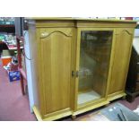 An Oak Break Fronted Bookcase, with a central glazed door, arched flanking cupboard doors, stepped