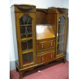 A 1920's Oak Side by Side Cabinet, with bowed and carved bookcases having lead glazed doors flanking