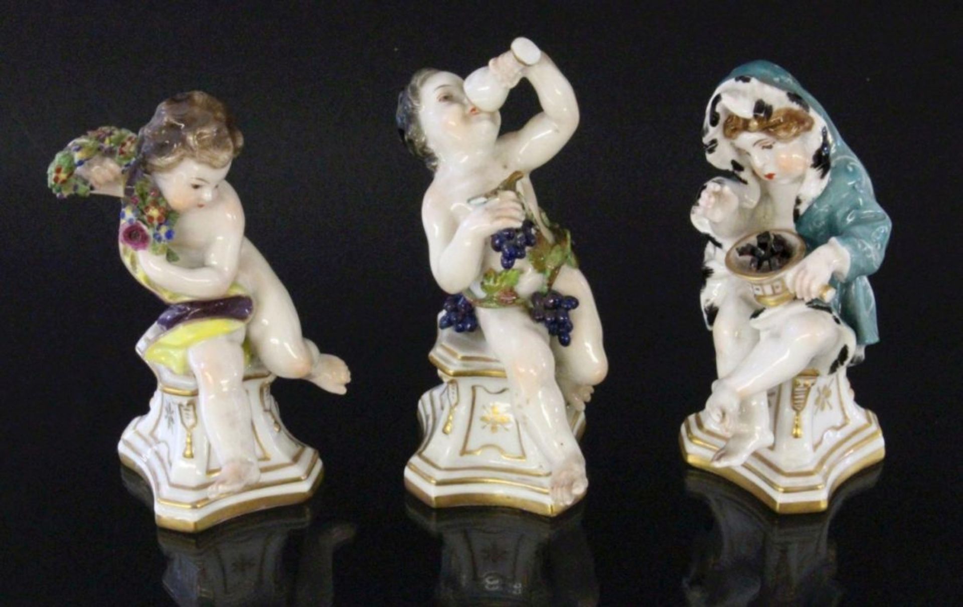 DREI JAHRESZEITENFIGUREN ENS, Volkstedt um 1900 Drei Putti auf goldstaffierten Podesten als