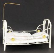 PUPPENBETTWeiß lackiertes Metall, mit Bettwäsche. 21x34x16cmA DOLL'S BED White lacquered metal, with