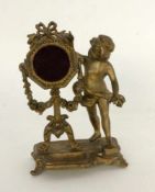 TASCHENUHRENSTÄNDERFrankreich um 1900 Putto neben einer Staffelei. Goldlackierter Metallguß. H.20cmA