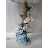 A large Lladro figural Lamp Base modelled as a courting couple with instruments under a tree, she