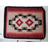 A 20th century American Navajo rug, geometric designs in red, black and brown, 82cm by 62cm